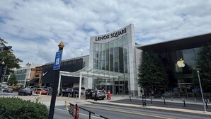 A Lenox Square building with a glass facade, a visible Apple logo, and a parking lot with cars. - FIFA World Cup - SuiteHearts Buckhead (Atlanta)