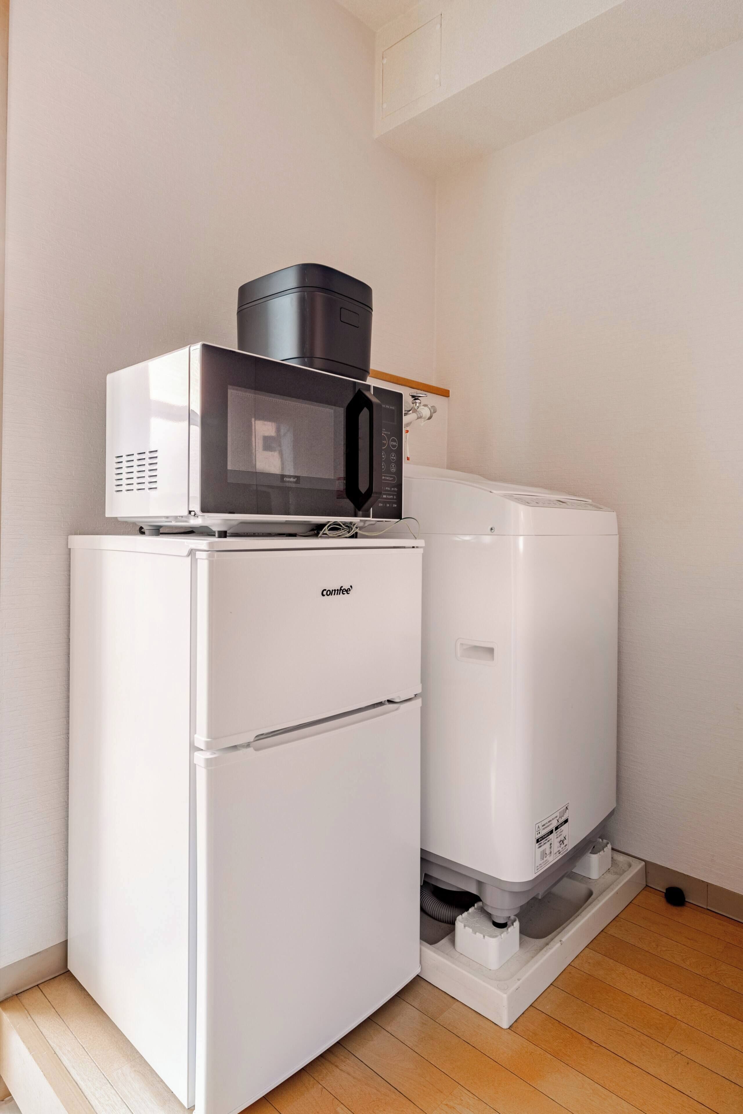 Una piccola cucina accessoriata con forno a microonde, macchina del caffè e frigorifero.