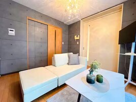 Una sala de estar moderna con un sofá, una mesa de centro y un televisor.