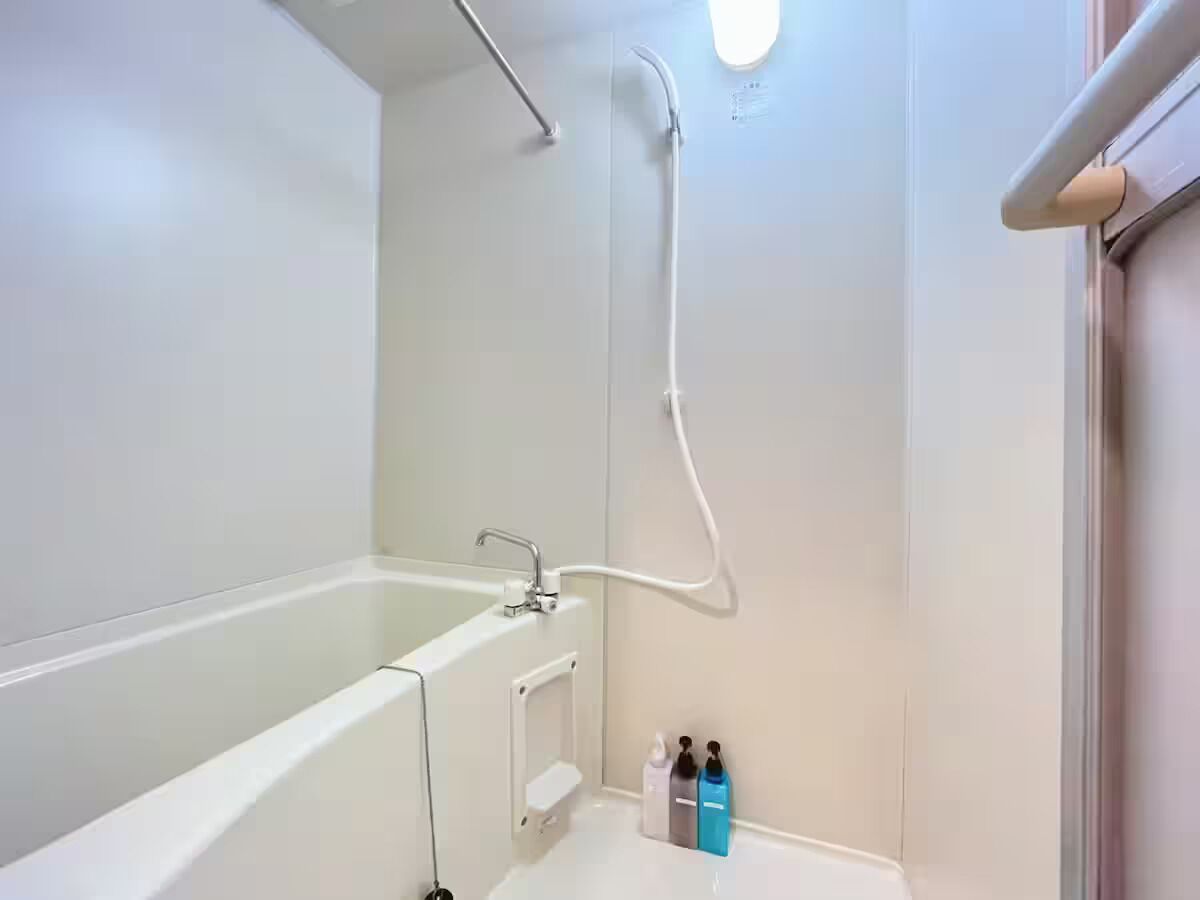 Et moderne badeværelse med badekar, bruser og gelænd.