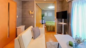 Ein modernes Wohnzimmer mit einer Couch, einem Fernseher und einem Essbereich.