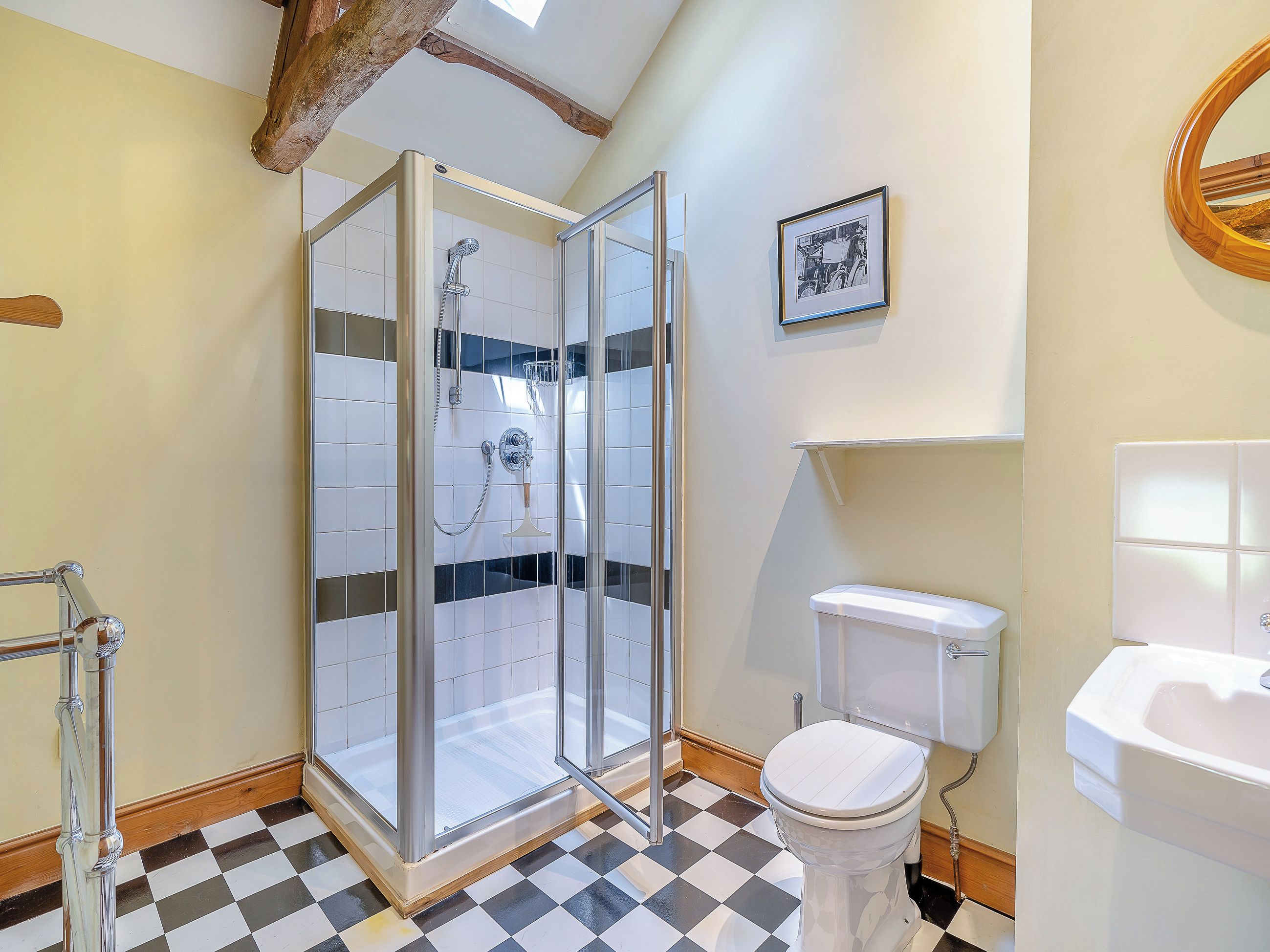 Un bagno con doccia vetro, un water e un lavandino.