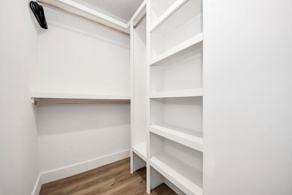 Un placard blanc avec plusieurs étagères et une étagère en bois.