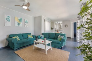 A living room with two teal sofas, a white coffee table, and a ceiling fan. - Holiday Home 'Betta' with Private Pool, Garden and Wi-Fi (Costa Calma)