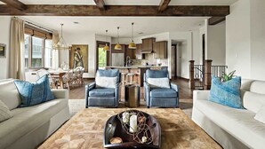 A spacious living room with a dining area, kitchen, and staircase. - Lake Travis Luxe Villa | 4BR | Pickleball | BBQ (Lake Travis)