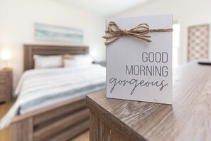 A bed with a white comforter and a wooden headboard.