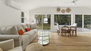 A modern living room with a sofa, coffee table, and dining area.