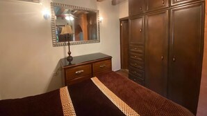 A bedroom with a bed, dresser, wardrobe, and a mirror. - Loft for executives/students, furnished and equipped, internet, cable (Monterrey)