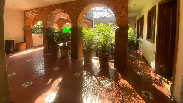 A covered corridor with brick arches, potted plants, and a tiled floor. - Loft for executives/students, furnished and equipped, internet, cable (Monterrey)