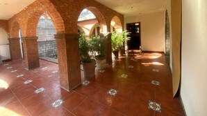 A spacious corridor with brick arches, tiled flooring, and potted plants. - Loft for executives/students, furnished and equipped, internet, cable (Monterrey)
