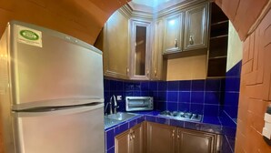 A compact kitchen with a refrigerator, a toaster, and blue-tiled walls. - Loft for executives/students, furnished and equipped, internet, cable (Monterrey)