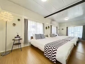 A hotel room with a large bed, a bedside table, and a floor lamp. - Higashitateishi kodate (Tokyo)