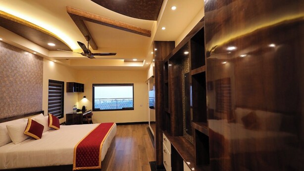 Une chambre d’hôtel moderne avec un grand lit, un bureau et une télévision.