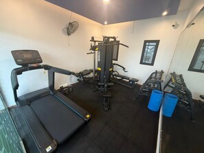 A gym with a treadmill, weight machines, and exercise mats. - Plachoos Gardens Kuttikkanam (Kuttikkanam)