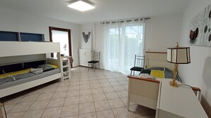 Une chambre moderne et bien éclairée, avec un lit superposé, un bureau doté d’une lampe et une chaise.