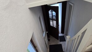 Un escalier avec un mur à texture et une fenêtre sur le côté gauche.