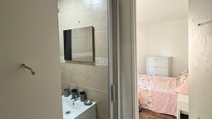 A bathroom with a sink, mirror, and tiled walls. - Studio 2 steps from Saint Charles station (Unknown)