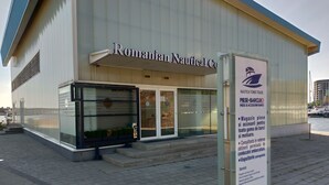 A building with a sign reading "Romanian Nautical Co." and a signboard listing services like ship repair and technical services.