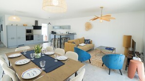 A modern living space with a dining area, kitchen, and seating area. - Villa Celestine - Ile d'Oléron - 6 pers - swimming pool (Saint-Denis-d'Oléron)