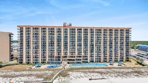 A multi-story hotel with a pool area, outdoor seating, and a beach view. - Oceanfront Phoenix V Condo Gulf Views & Balcony  OrangeBeach 3Bed 2Bath 14th flr (Orange Beach)
