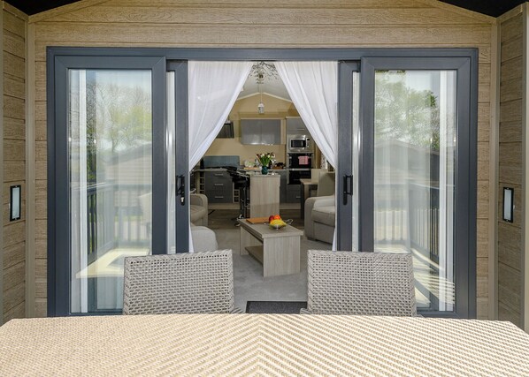 A modern room with a large sliding glass door leading to a kitchen and living area.