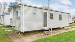 A single mobile home with a front door, a small window, and a side door. - 2 bedroom accommodation in Talacre, Holywell (Talacre, Holywell)