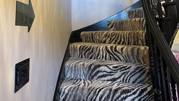 A staircase with zebra-patterned carpet leading to a room. - Beachview  (Peterhead)