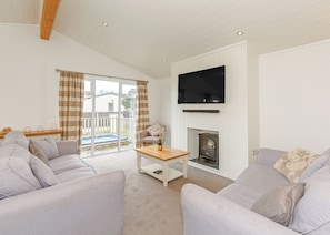 A living room with a fireplace, a television, and a sofa.