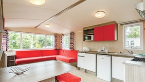 A compact kitchen with a red bench, a microwave, and a sink. - 3 bedroom accommodation in Talacre, Holywell (Talacre, Holywell)