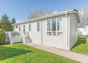 A single-story mobile home with a front porch, a small set of stairs, and a visible window. - Willow Tree 3 Premier (Talacre, Holywell)
