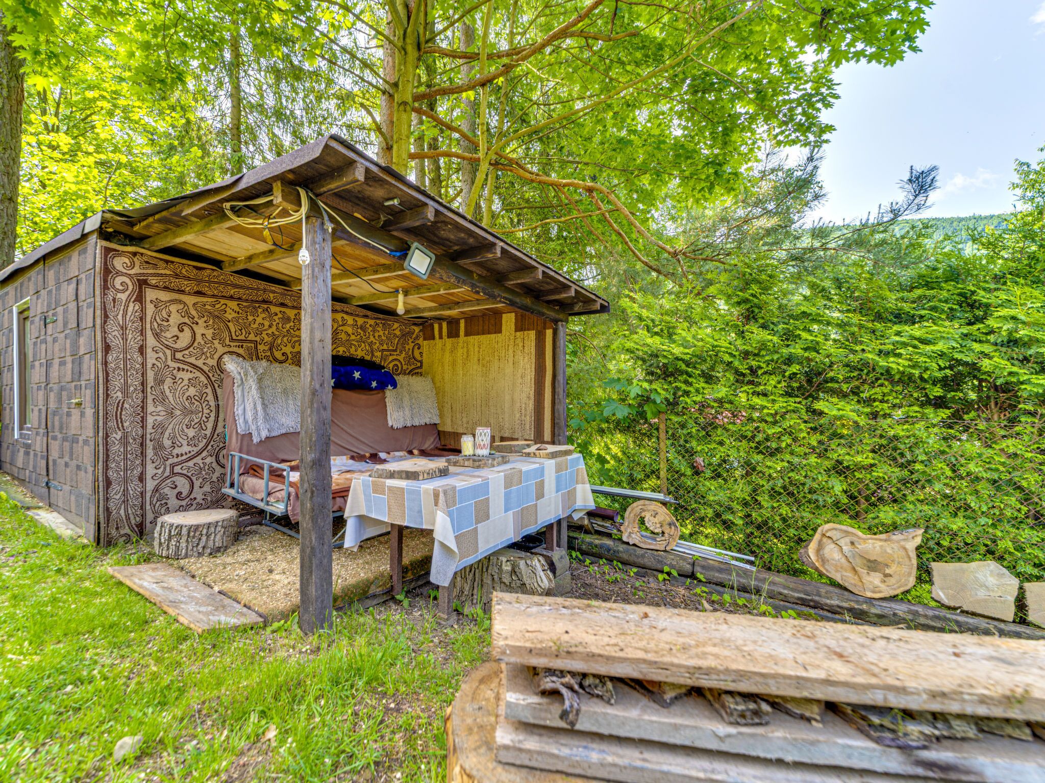 Een eenvoudige chalet met een bed, een tafel en een kleine keukenhoek.