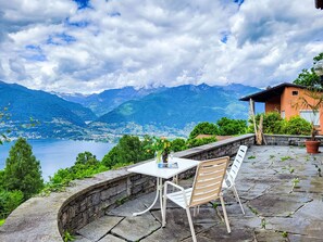 A terrace with a table and chairs overlooking a lake and mountains. - Studio Indèman by Interhome (Vairano)