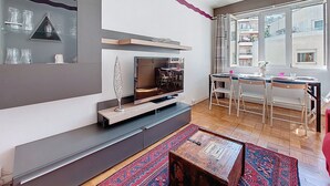 A modern living room with a fireplace, a dining area, and large windows. - Apartment Daphné by Interhome (Nice)