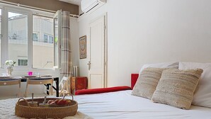 A bedroom with a bed, a window, a desk, and a wicker basket with cups. - Apartment Daphné by Interhome (Nice)