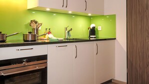 A kitchen with white cabinets, a green countertop, and stainless steel appliances. - Pasadena by Interhome (Zermatt)