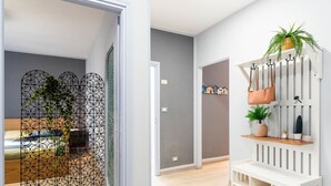 A modern bedroom with a bed, a decorative metal partition, and a white console table with a plant and a handbag. - casa Peggy by Interhome (Santo Stefano al Mare)