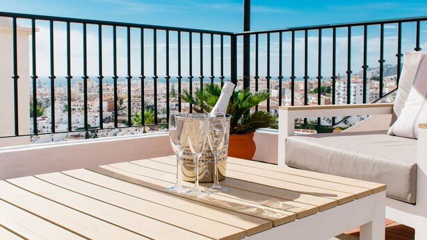 A balcony with a white table, a potted plant, and a white sofa. - Villa, 3 Terraces, 5-Min Walk to Burriana Beach (Nerja)