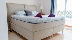 A bed with a floral-patterned duvet, two pillows, and two rolled towels. - Villa, 3 Terraces, 5-Min Walk to Burriana Beach (Nerja)