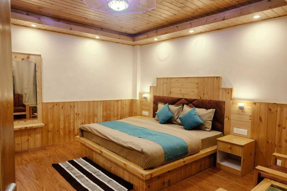 Ένα υπνοδωμάτιο με ξύλινη επένδυση στους τοίχους, που περιλαμβάνει ένα κρεβάτι, κομοδίνα και ένα παράθυρο.