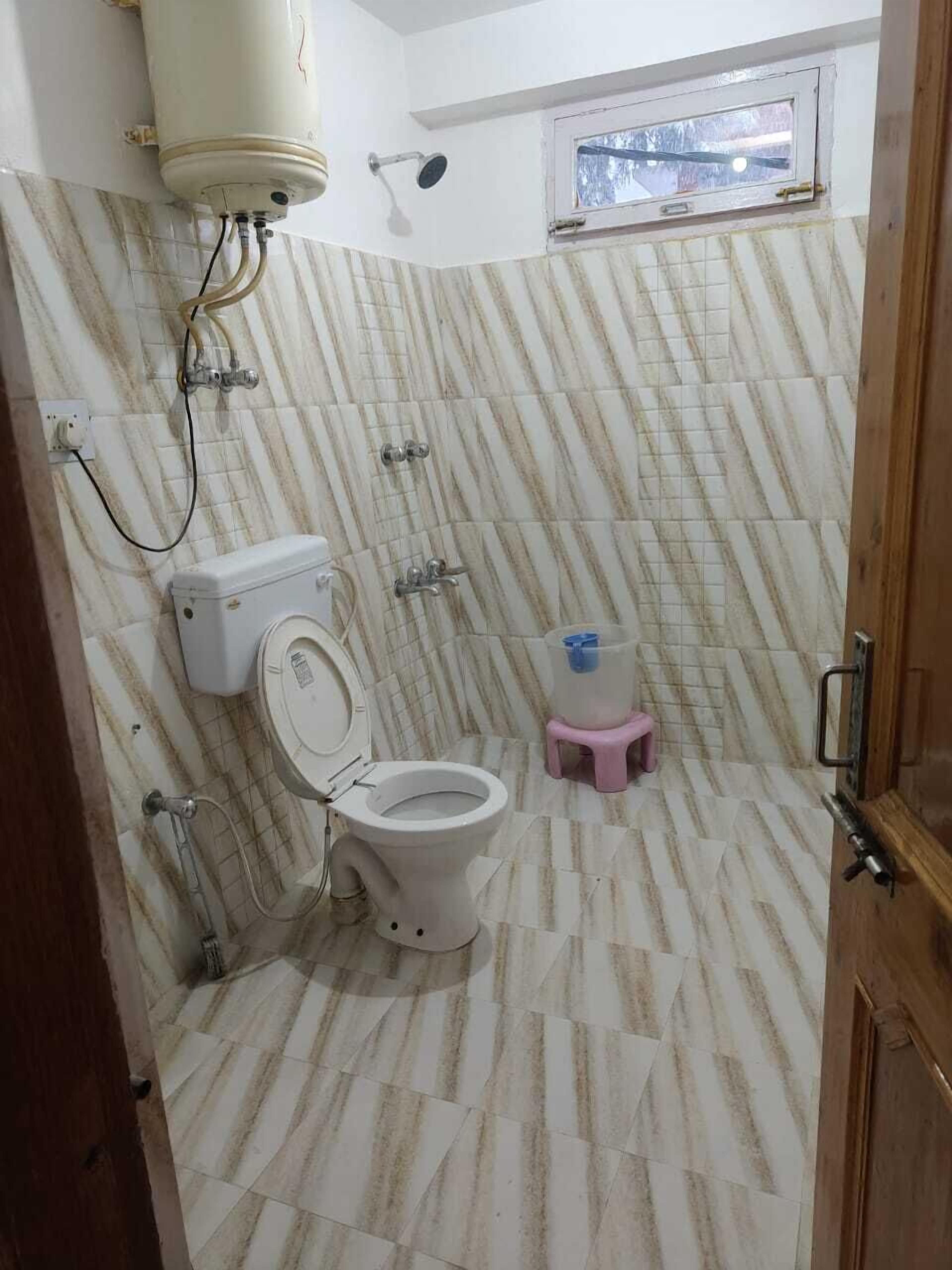 Une salle de bain équipée de toilettes, d’un bidet et d’une douche.