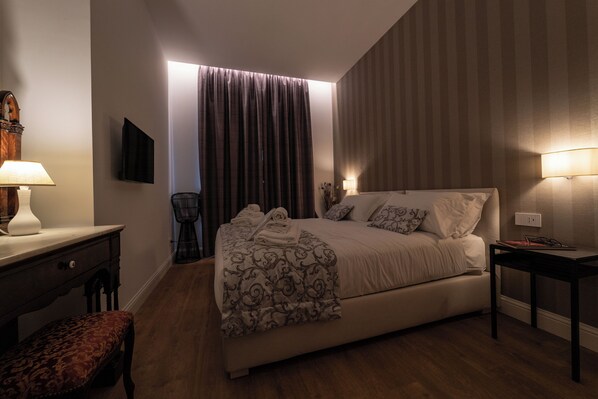 Une chambre bien rangée, avec un lit, des tables de chevet, une chaise et un bureau.