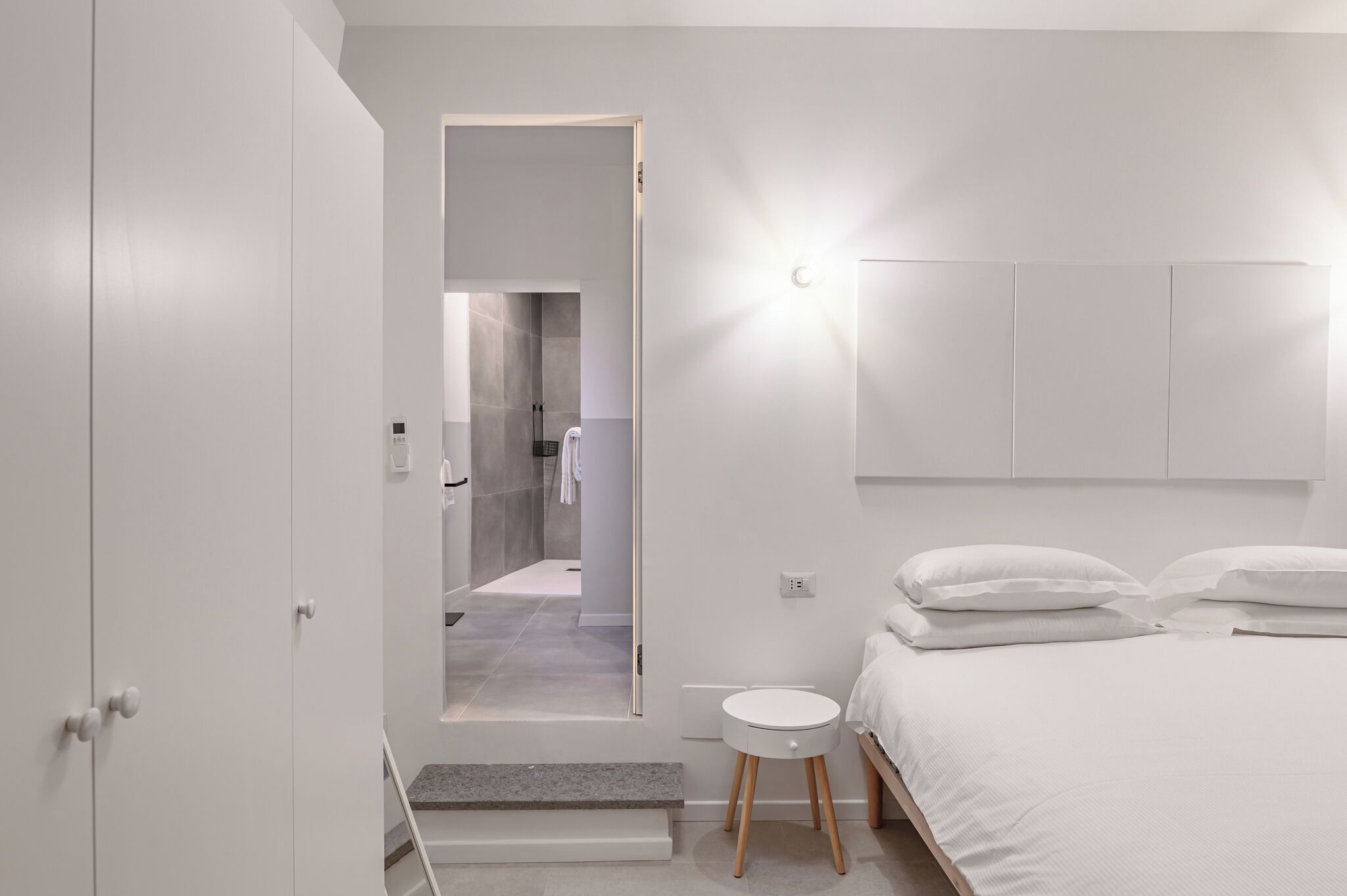 Un dormitorio moderno con cama, mesitas de noche y armario.