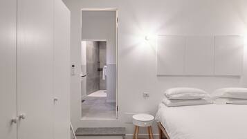 Une chambre à coucher moderne, avec un lit, des tables de chevet et une armoire.