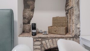 A stone fireplace with a woven basket and a black object on the mantel. - Basco Guest House (Viterbo)