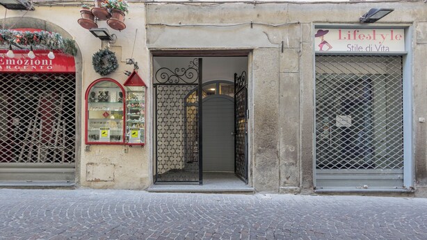 A storefront with a sign reading "Lifestyles Stile di Vita" and a shop with a red awning. - Basco Guest House (Viterbo)