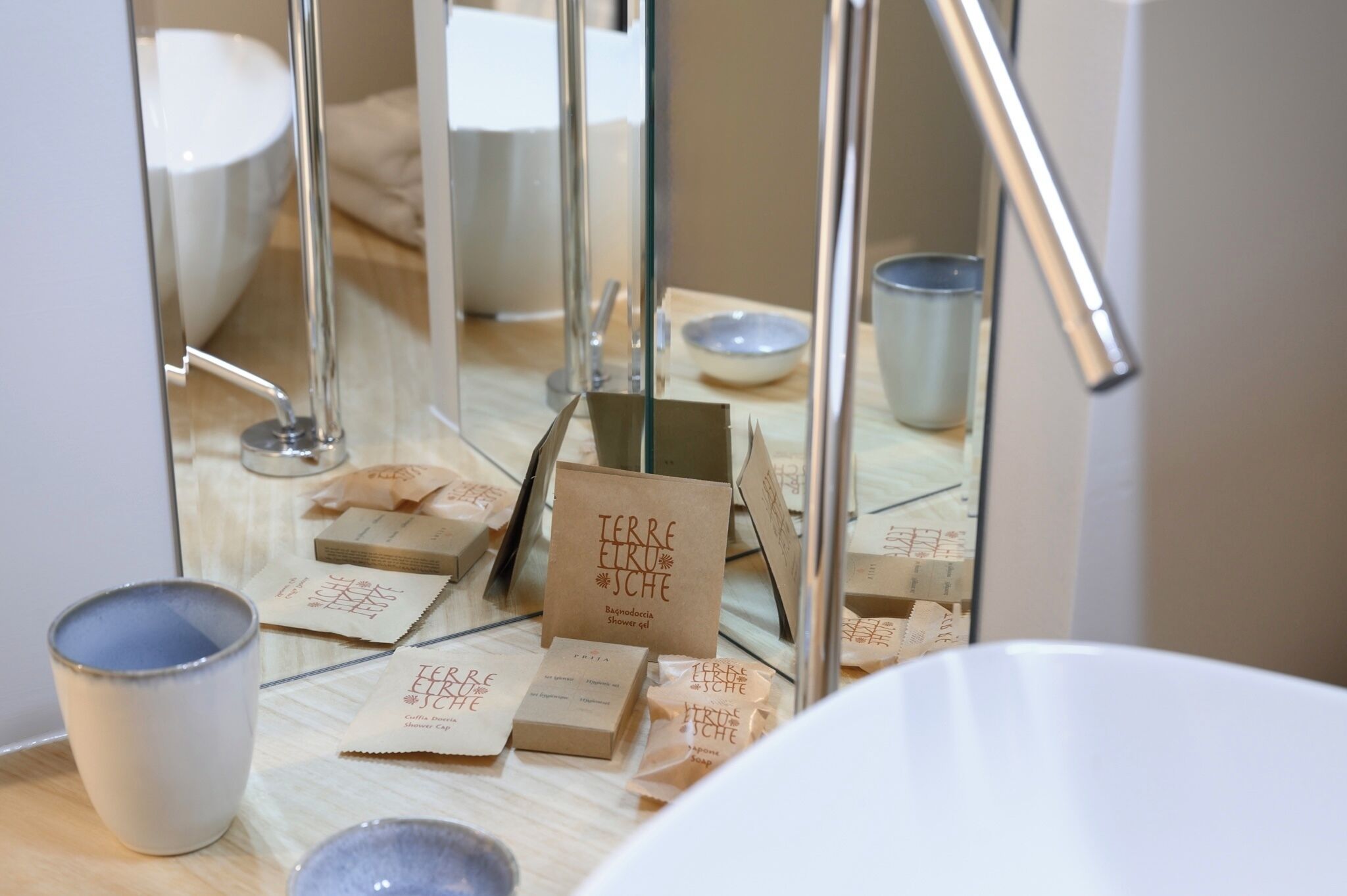 Een badkamer met een spiegel, een wastafel en diverse toiletartikelen.