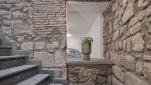 A stone staircase leading to a doorway with a potted plant on a ledge. - Basco Guest House (Viterbo)