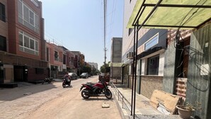 Un carrer amb edificis, una moto i un cotxe.