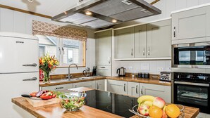 A modern kitchen with a built-in stove, a microwave, and a refrigerator. - 1 bedroom accommodation in Greystoke, Nr Ullswater (Greystoke, Nr Ullswater)