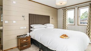 A bedroom with a bed, bedside table, and a window with curtains. - 1 bedroom accommodation in Greystoke, Nr Ullswater (Greystoke, Nr Ullswater)